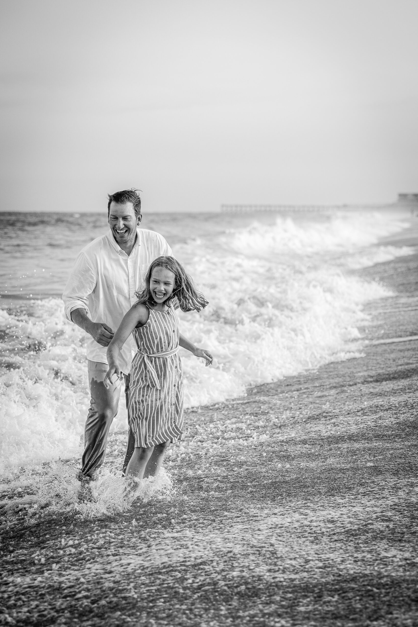 A dad laughs with his daughter as they play in the water during things to do in wilmington with kids