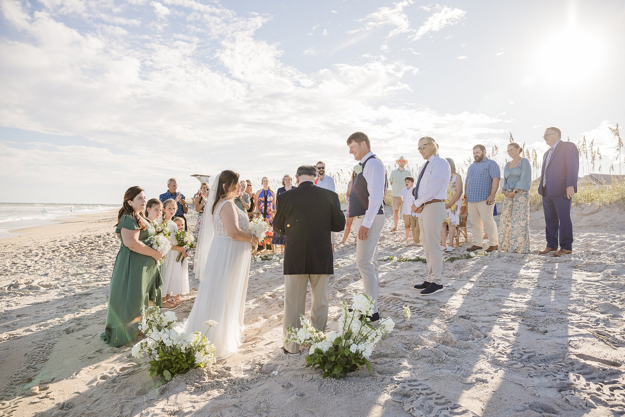 Newlyweds stand with family and friends during their wrightsville beach wedding and elopement ceremony