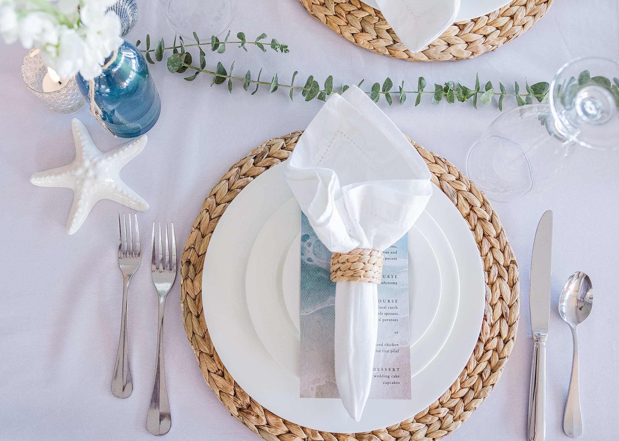 Details of a beach themed wedding reception table setting